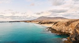 Drone vista da praia de areia com água azul-turquesa limpa no dia ensolarado de verão em Fuerteventura, Espanha — Fotografia de Stock