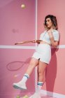 Young sportswoman in sneakers and sports clothes standing with tennis rackets while looking away — Stock Photo