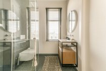 Weiße Keramik-Waschbecken und Toilette in der Nähe von Dusche und Badewanne im modernen Badezimmer mit pastellgrünen Wänden — Stockfoto