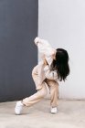 Повна довжина творча жіноча танцівниця в білому одязі танцює на міській вулиці під час виступу — стокове фото