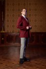 Classy adult male theater artist in burgundy jacket and with makeup looking at camera with arrogance — Stock Photo