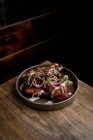 De cima de deliciosas asas de frango assado em molho de churrasco decorado com legumes frescos servidos em prato em mesa de madeira no restaurante — Fotografia de Stock