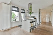 Modernes Wohndesign mit Kücheninsel mit Theke und Hockern unter der Haube in geräumiger offener Wohnung im Loft-Stil — Stockfoto