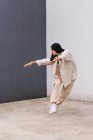 Talentierte Tänzerin bewegt sich und tanzt in der Nähe einer Betonmauer im Stadtgebiet — Stockfoto