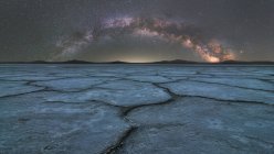 Spektakuläre Szenerie glühender Sterne der Milchstraße am Nachthimmel über der trockenen Salzlagune bei Langzeitbelichtung — Stockfoto