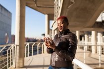 Side view of beautiful Afro woman communicating with her smartphone — Stock Photo