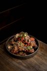 Angolo alto di deliziose ali di pollo alla griglia con salsa barbecue e peperoni piccanti messi sul tavolo nel ristorante — Foto stock