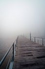 Lumber quay with metal railings located on shore of Tagus River in misty morning in Lisbon, Portugal — Stock Photo