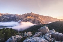 Szenische Ansicht von Pedriza mit Nebelschwaden zwischen dem Guadarrama-Gebirge und Felsbrocken mit Nadelbäumen bei Sonnenaufgang in Spanien — Stockfoto
