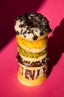 From above tower of donuts of different colors and flavors on pink background — Stock Photo