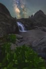 Magnifique paysage de cascades mousseuses coulant parmi les terrains rocheux rugueux sous le ciel étoilé nocturne avec la Voie lactée brillante — Photo de stock