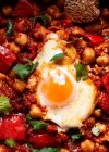 Chakchouka von oben mit sonnigem Ei in köstlicher Tomatensauce mit Roggenbrot in Schüssel — Stockfoto
