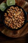 Вид зверху купа зерна зернових в мисці і лайма, розміщені на дерев'яному столі на кухні — стокове фото
