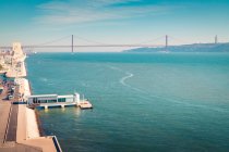 Drone view of contemporary quay located near embankment on coast of Tagus River near Torre de Belem Garden and not far from 25 de Abril Bridge at daytime in Lisbon, Portugal — Stock Photo