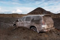 Todo o veículo terrestre coberto com terra e areia vulcânica após erupção contra Fagradalsfjall durante o dia na Islândia — Fotografia de Stock