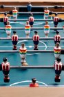 Alto ángulo de detalle de futbolín retro con figuras en miniatura de madera de jugadores en barras de metal - foto de stock