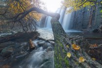 Vue panoramique de cascades coulant vers le bas des roches dans les bois montagneux en automne en longue exposition à la rivière Lozoya dans le parc national de Guadarrama — Photo de stock