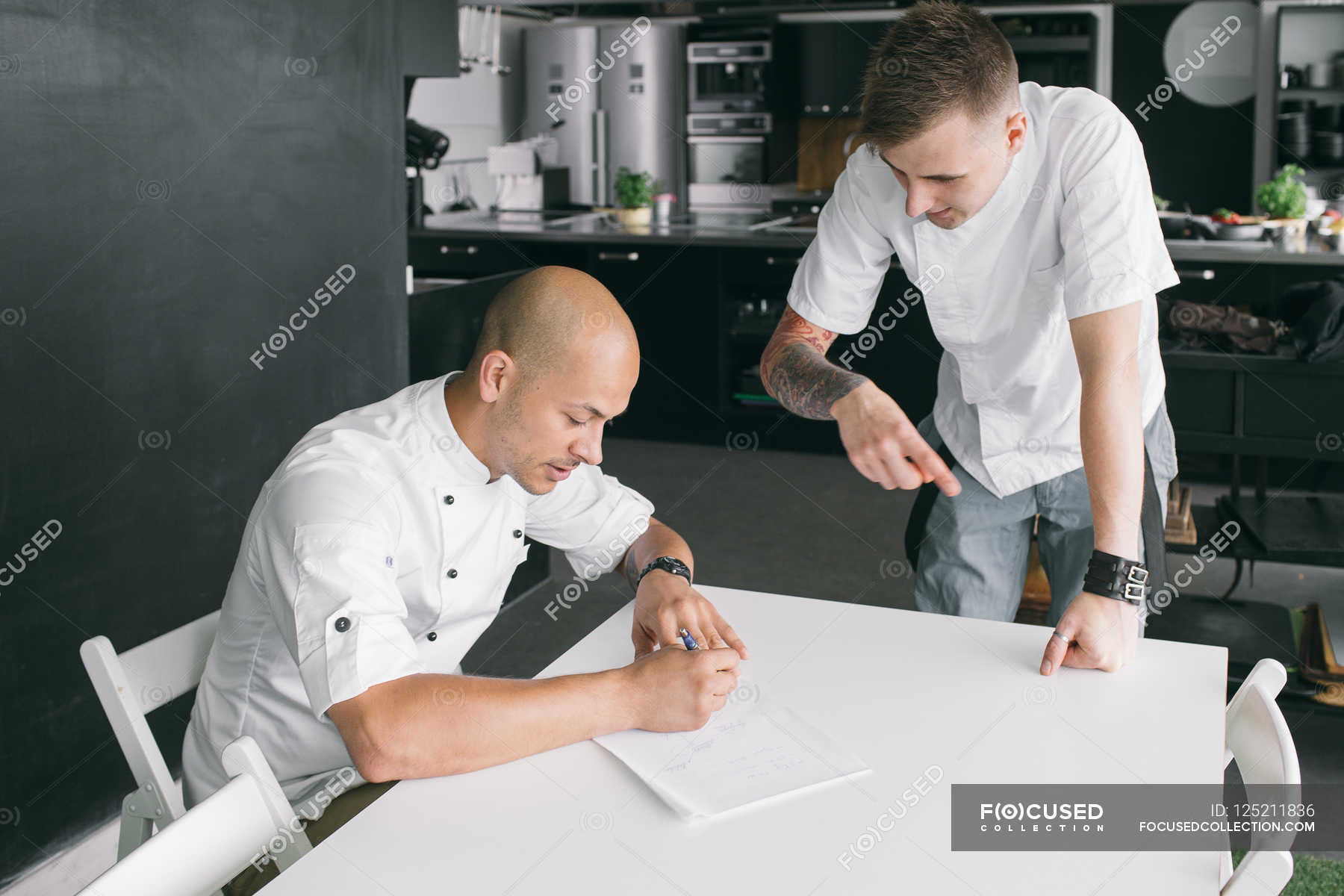 Chef writing on paper with student — professional, faces - Stock Photo ...