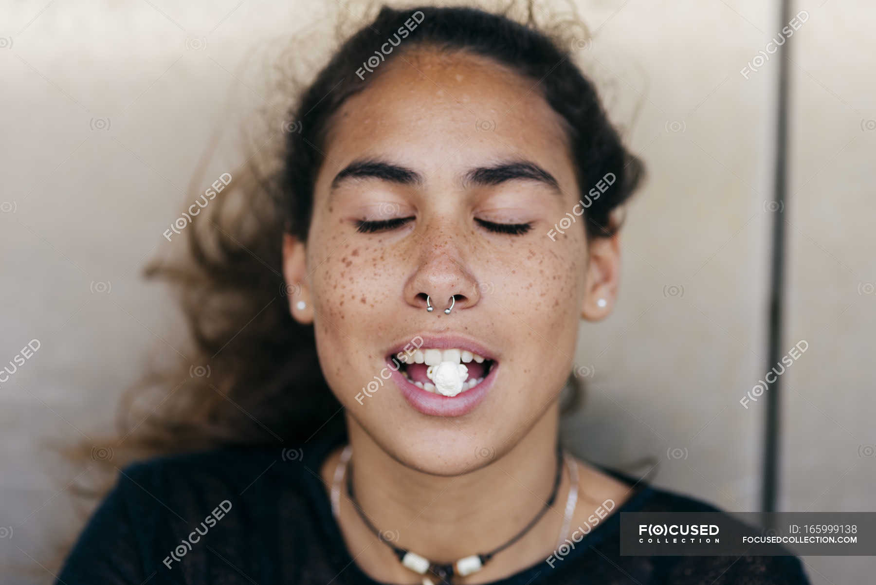 Girl with popcorn in mouth — casual, copy space Stock Photo 165999138