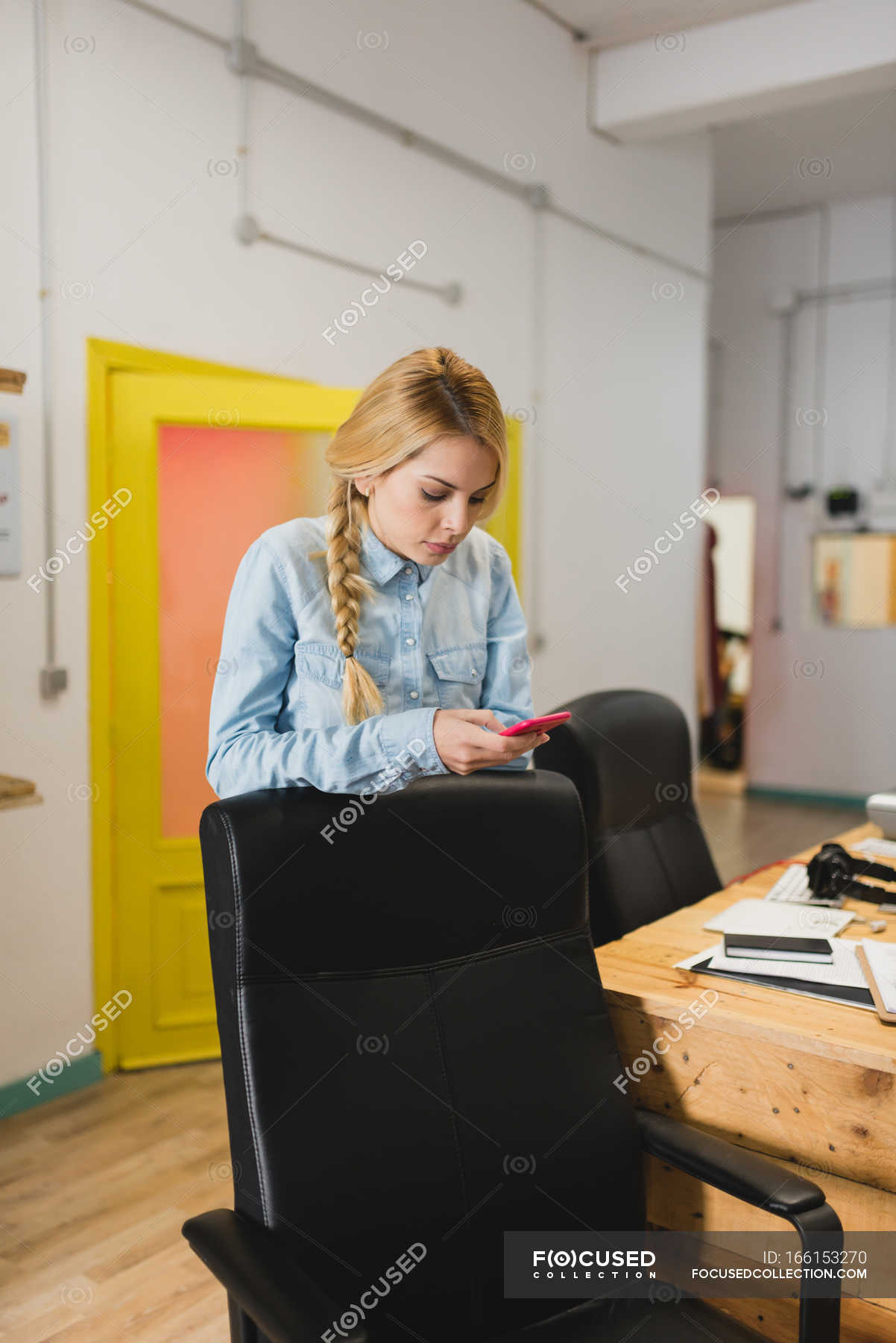 Portrait of blonde businesswoman leaning on office chair and browsing  smartphone — person, indoors - Stock Photo | #166153270