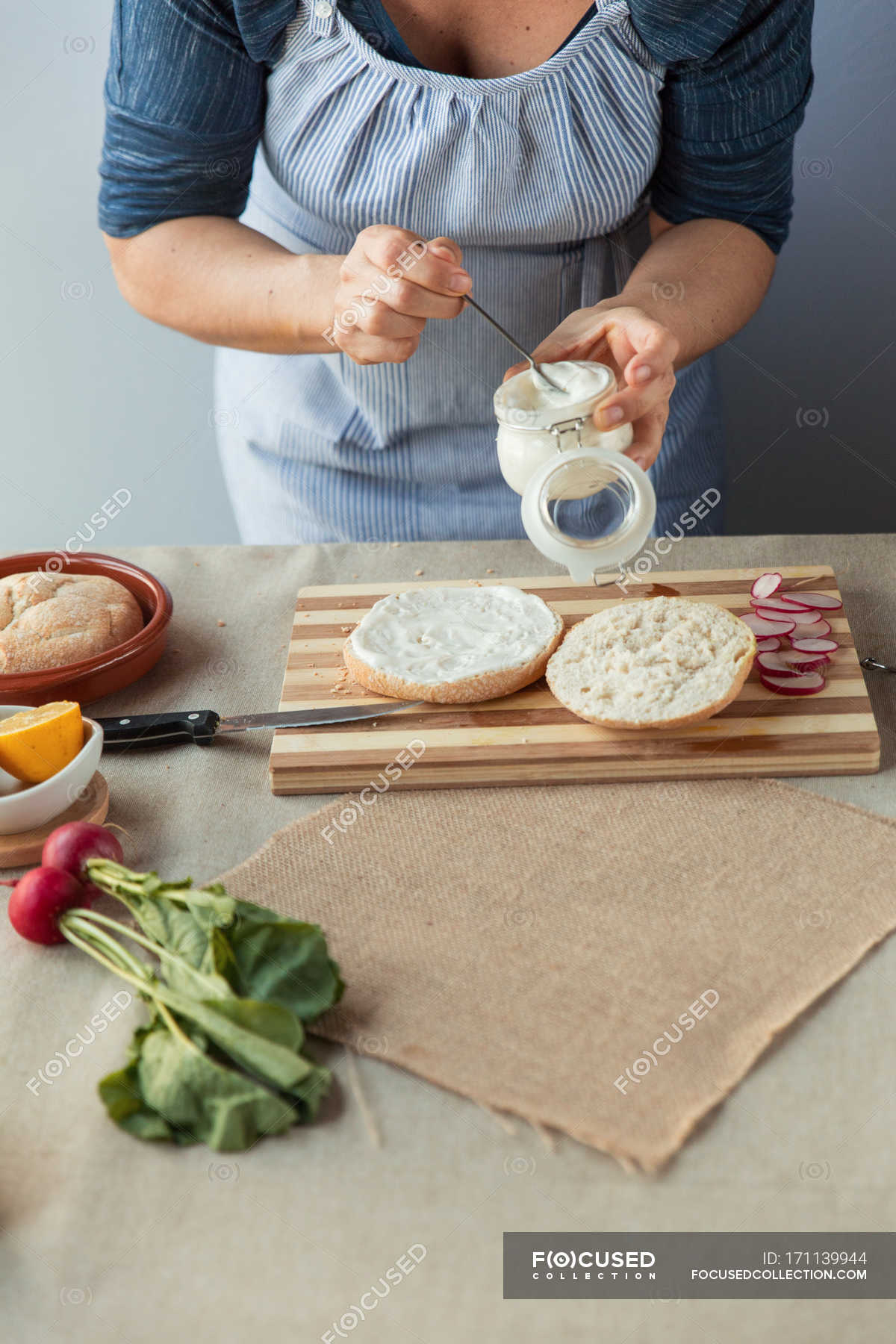 Cook spreading sauce on bun — organic, nutrition Stock Photo 171139944