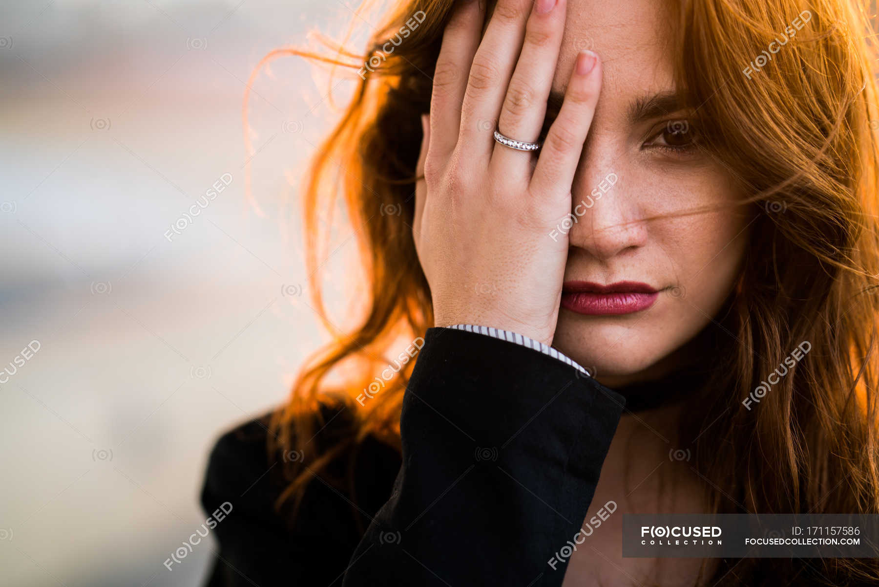 Portrait Of Woman Closing One Eye With Hand And Looking At Camera — City Outdoors Stock 