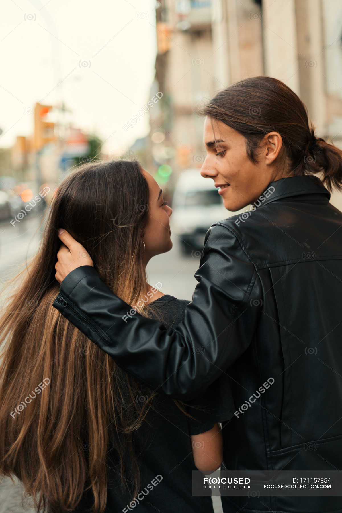 Back view of couple walking on street together and looking each one. —  vertical, long hair - Stock Photo | #171157854