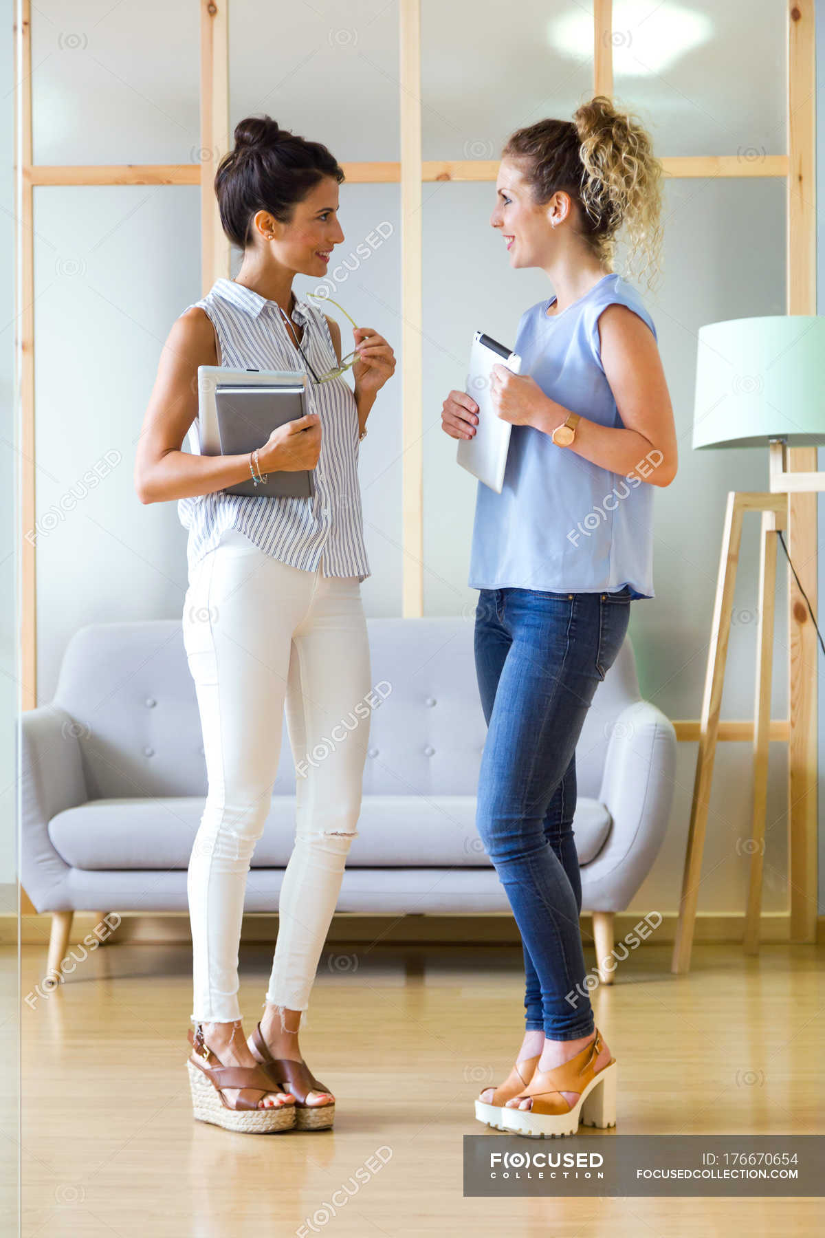 Portrait Of Two Business Women Talking In Office Scene Bright   Focused 176670654 Stock Photo Portrait Two Business Women Talking 