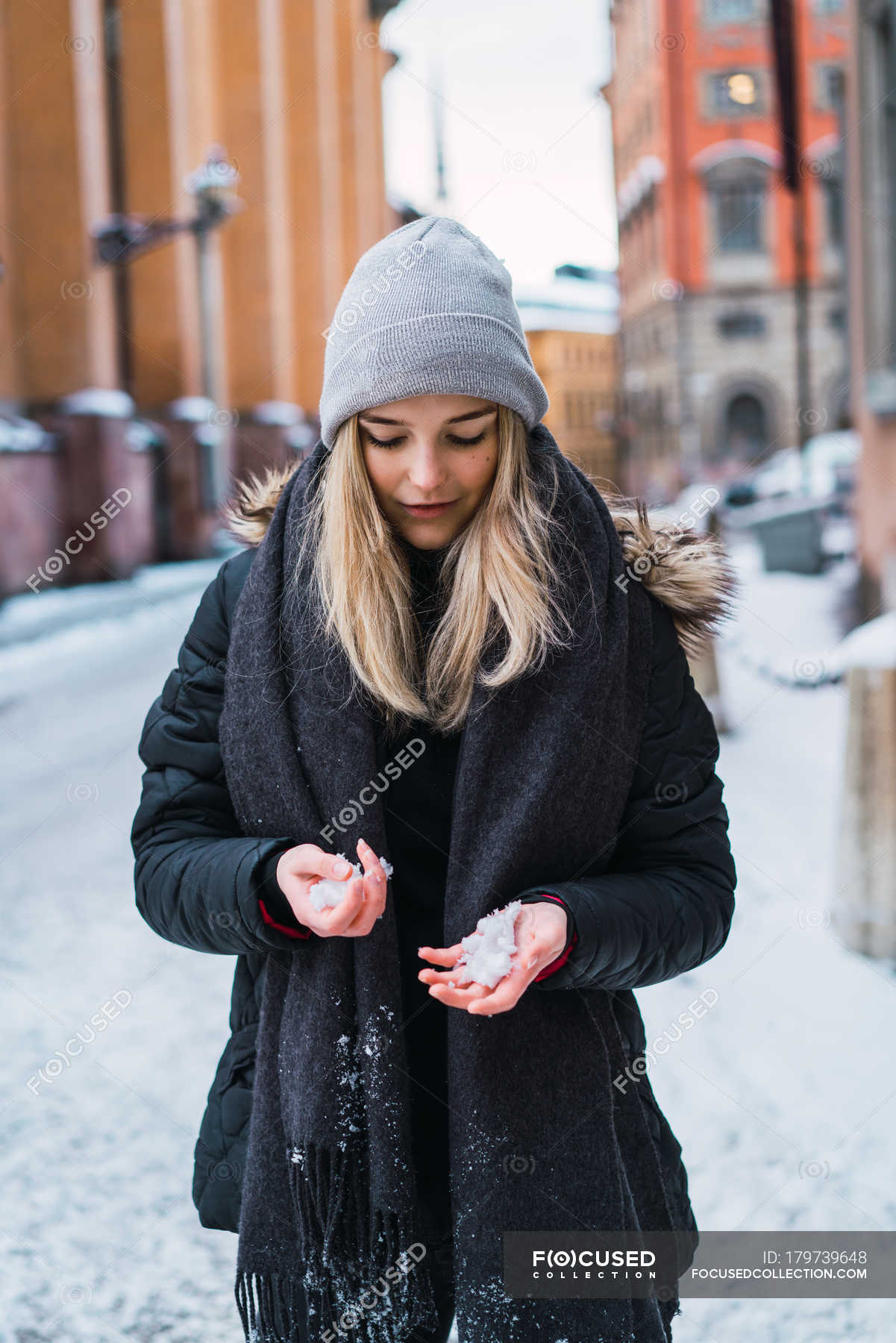 Портрет блондинки, смотрящей на снег в руках на зимней улице — Одежда, на открытом воздухе - Stock Photo