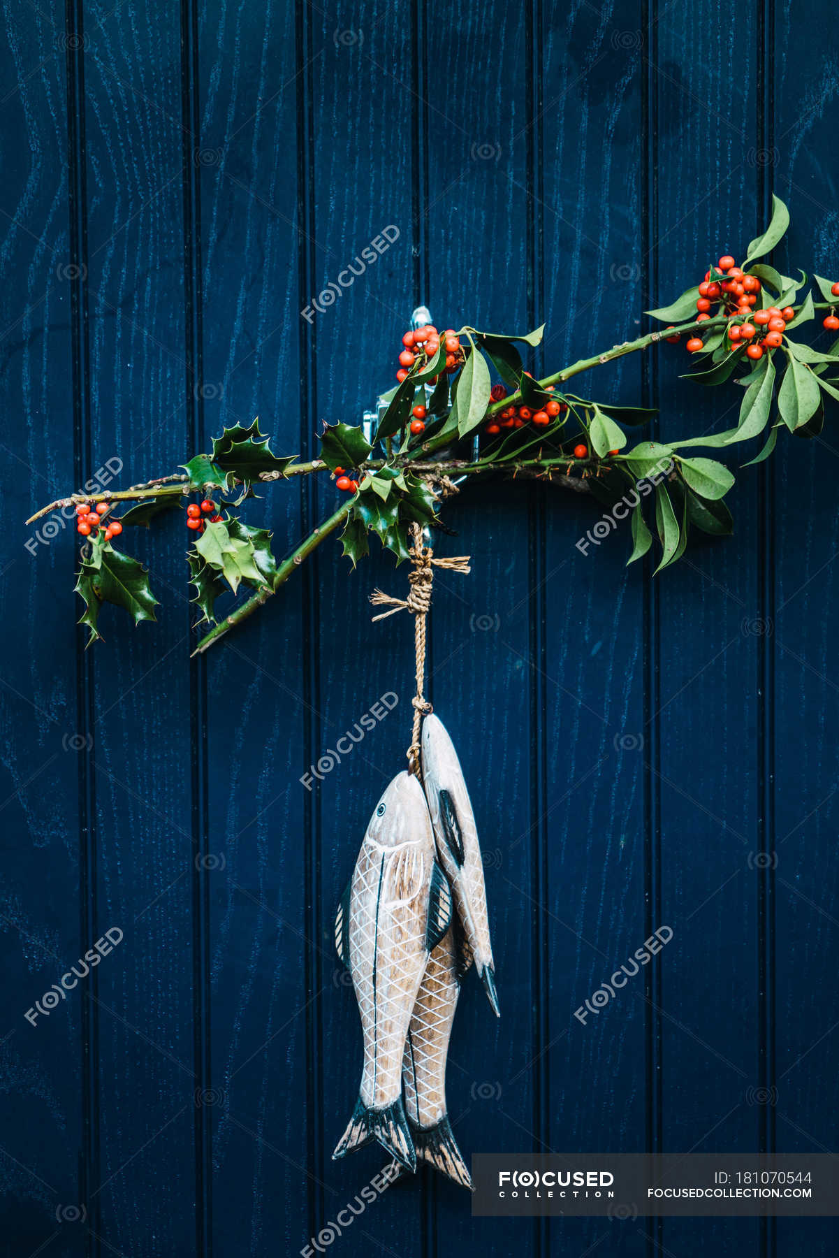 Branches With Berries And Fish Decoration Hanging On Blue Wooden