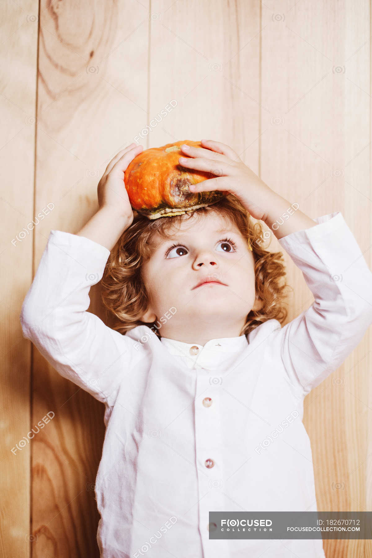 Child boy posing with pumpkin on head — kid, traditional Stock Photo