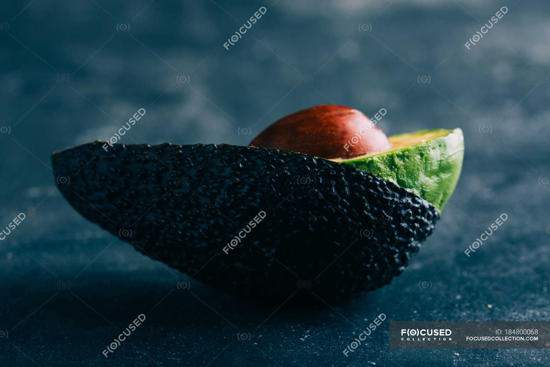 Halved avocado on dark background — guacamole, Dieting - Stock Photo