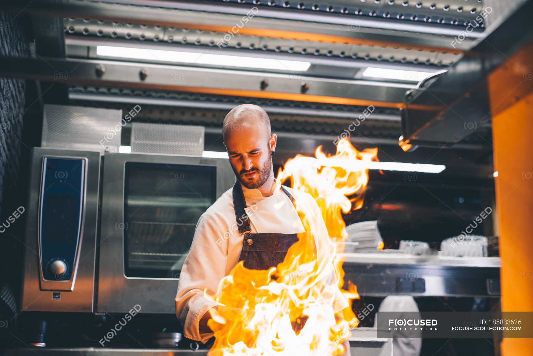 Fire flame over cook making flambe in restaurant — lunch, oven Stock