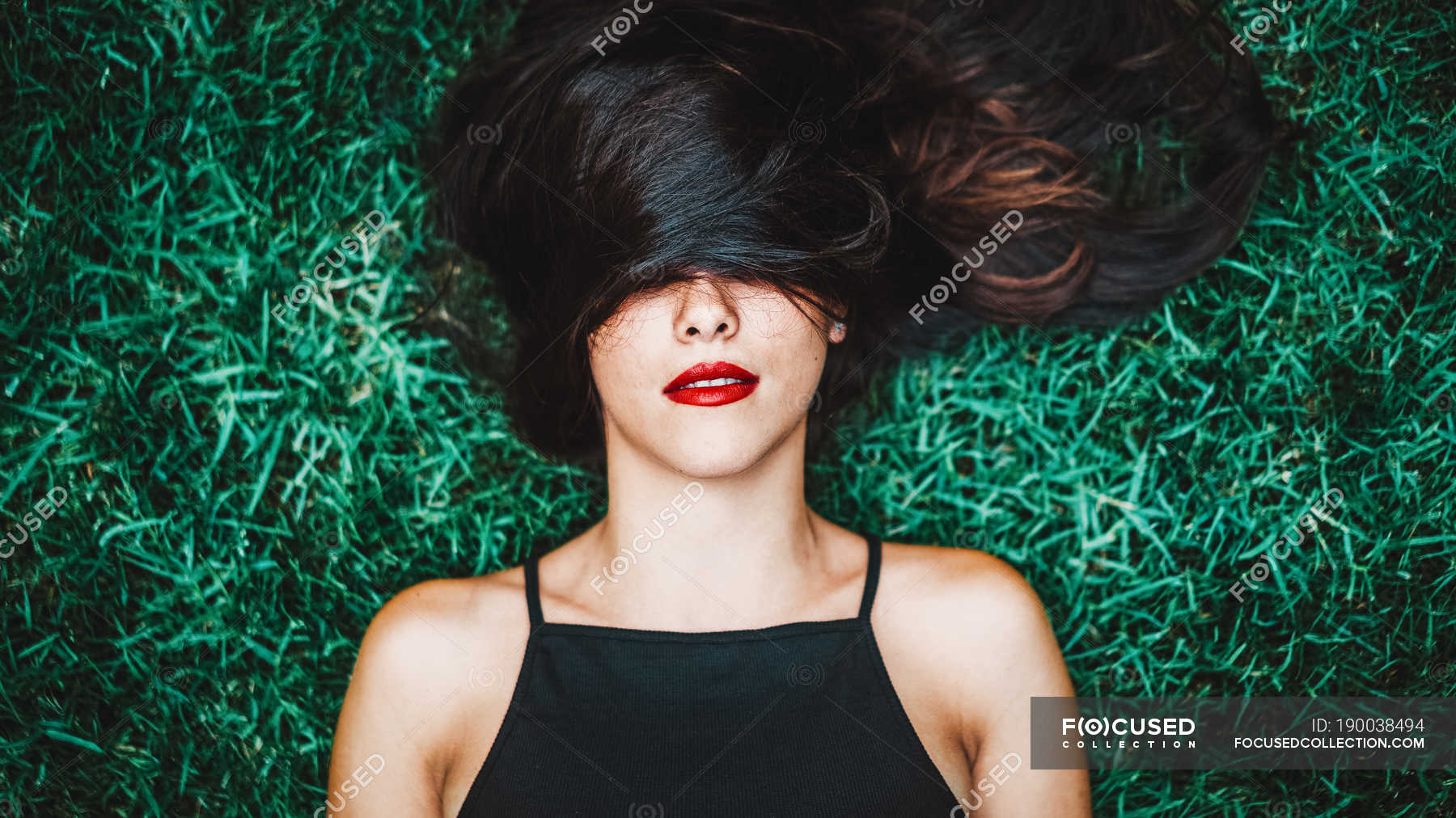 Cheerful Brunette Woman Lying In Grass With Lock Of Hair Over Eyes — Glamour Attractive Stock