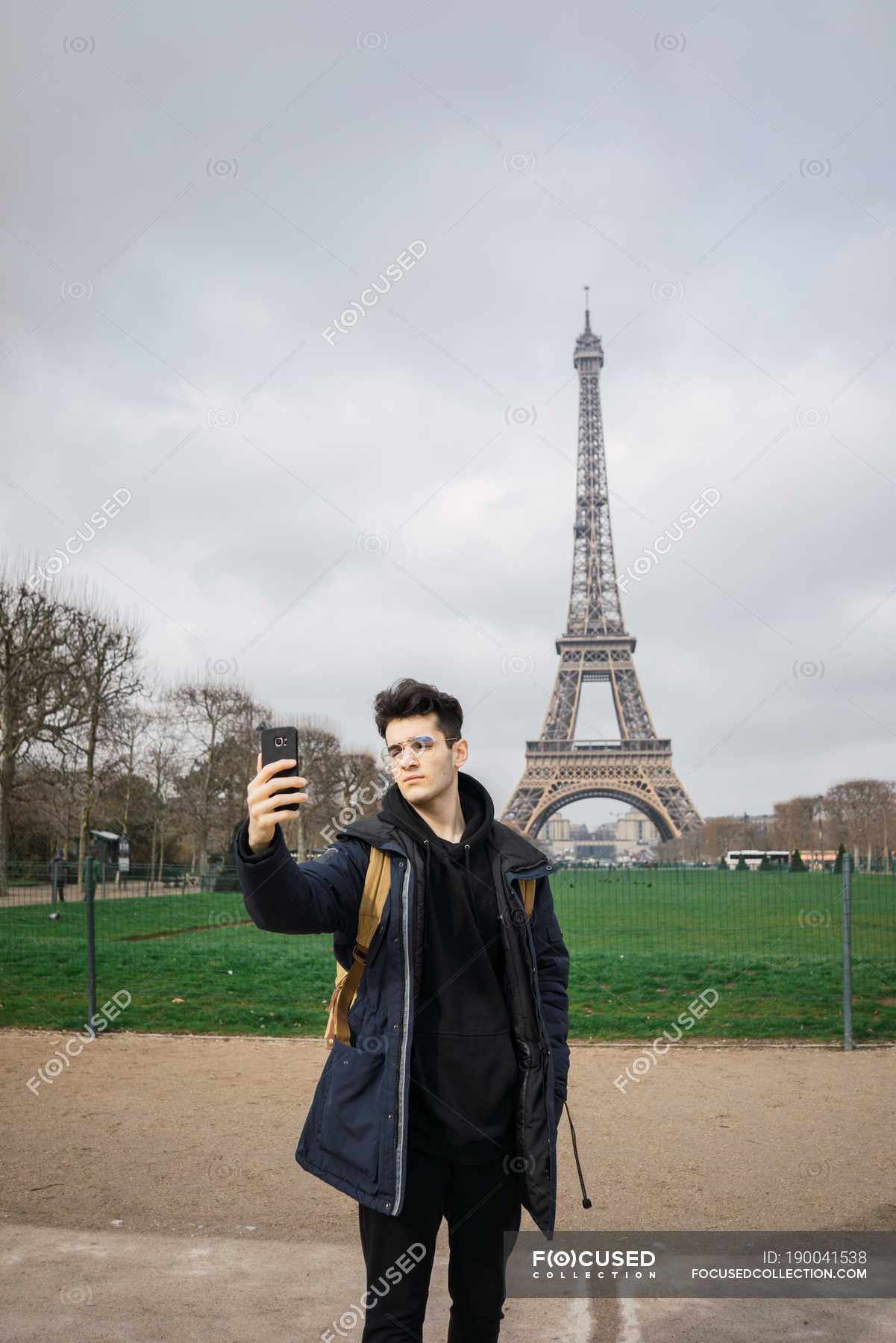 Young tourist man standing with phone and taking selfie on background of  Eiffel tower. — male, people - Stock Photo | #190041538