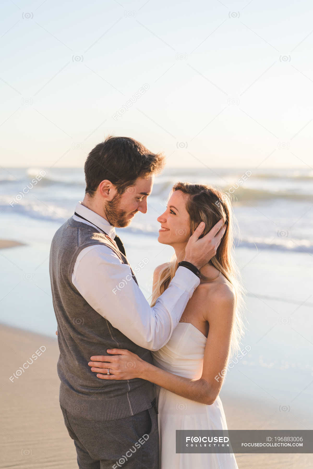 Tender Bridal Couple Posing On Beach In Sunlight Embraced Side