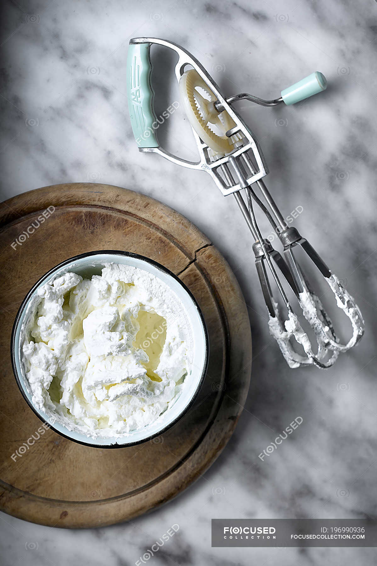 From above of whipped cream in bowl and manual beater — still life