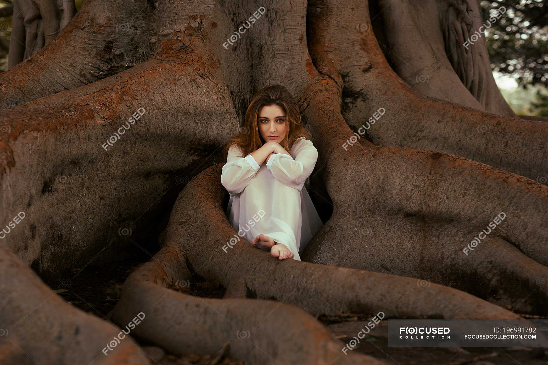 https://st.focusedcollection.com/9163412/i/1800/focused_196991782-stock-photo-pensive-woman-sitting-tree-roots.jpg