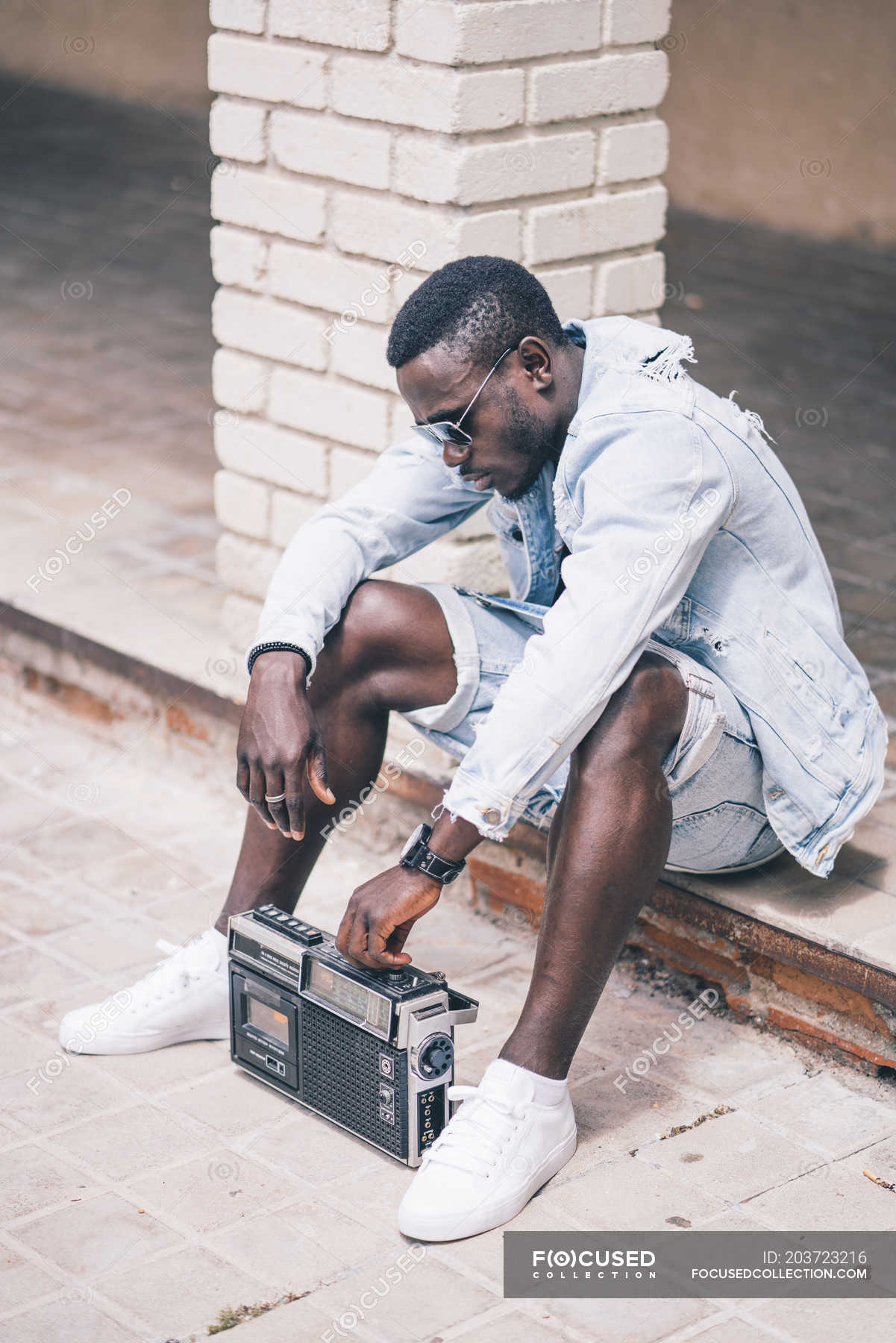 Black Man Sitting On Floor With Vintage Radio Device Fashionable