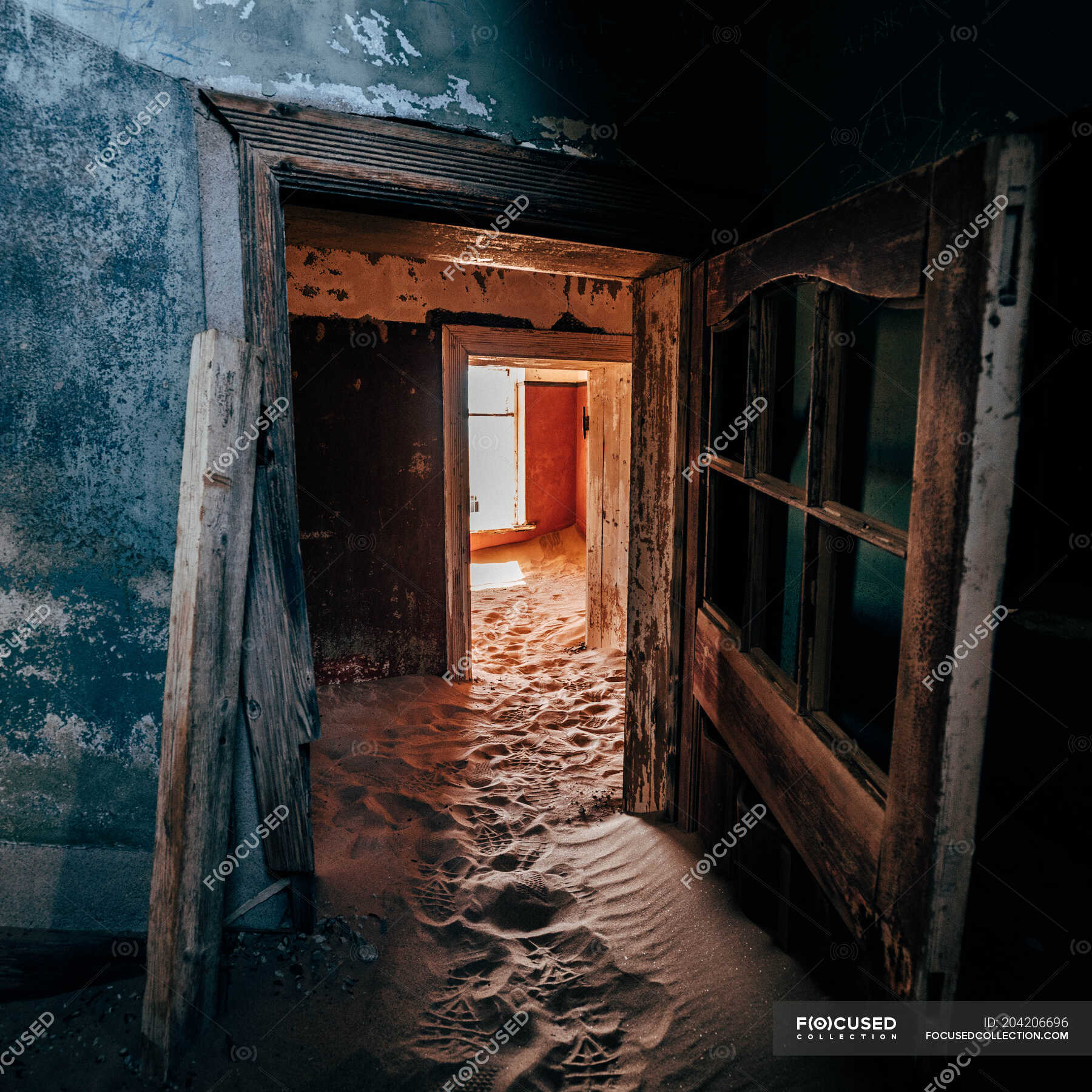 Puertas e interior en antiguas casas abandonadas con suelo cubierto de  arena. — Dañado, Abandonar - Stock Photo | #204206696