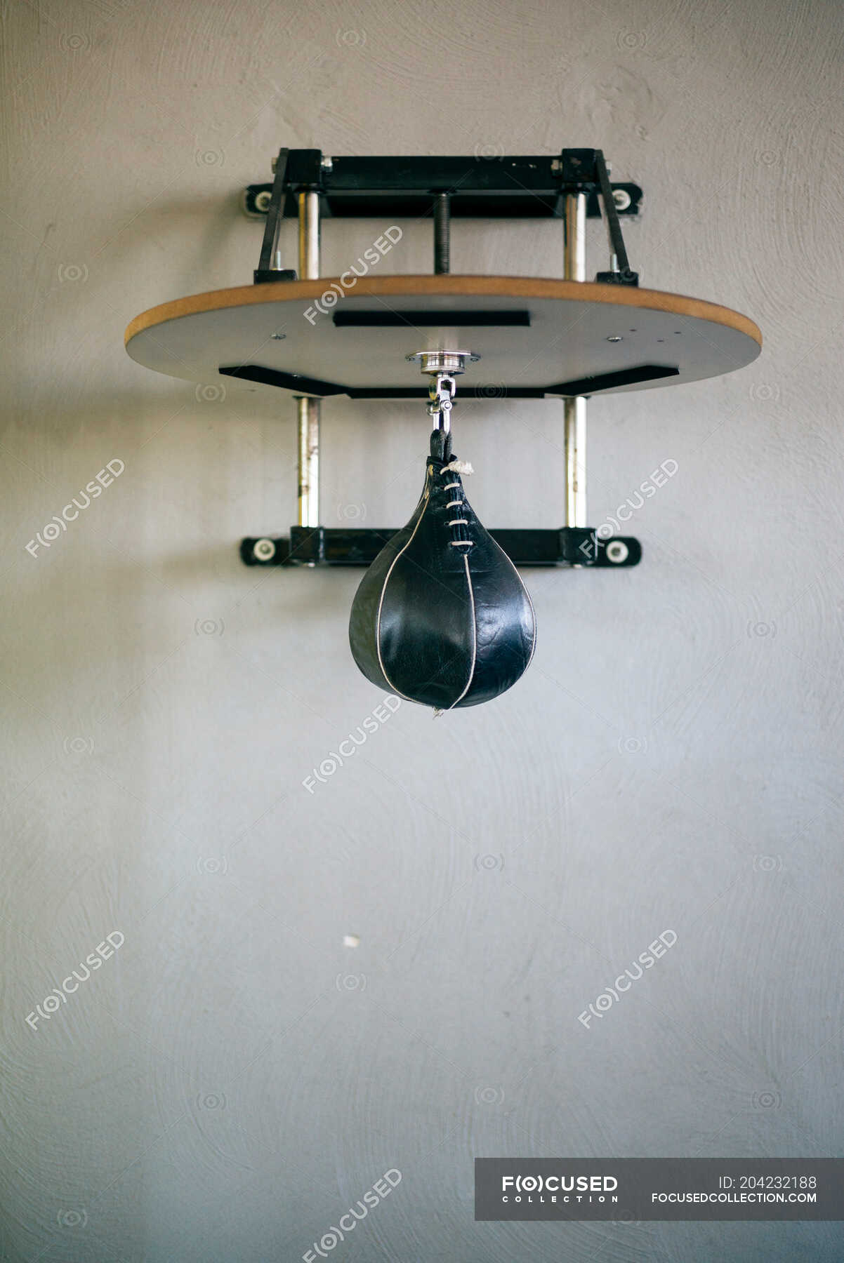 Small punch bag for stamina exercise hanging on gray wall. — 0 NO