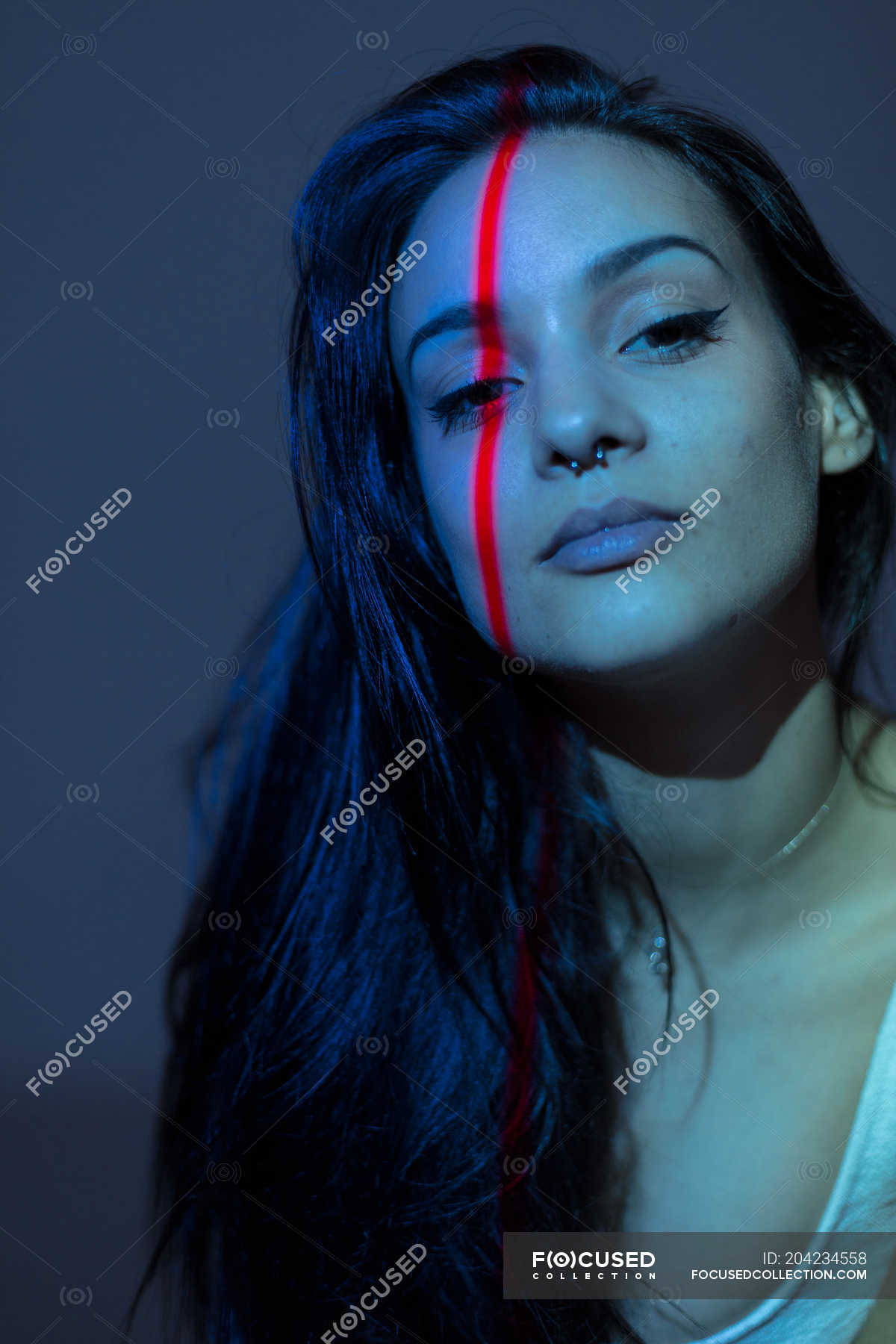 young-attractive-woman-with-red-line-on-face-standing-on-grey