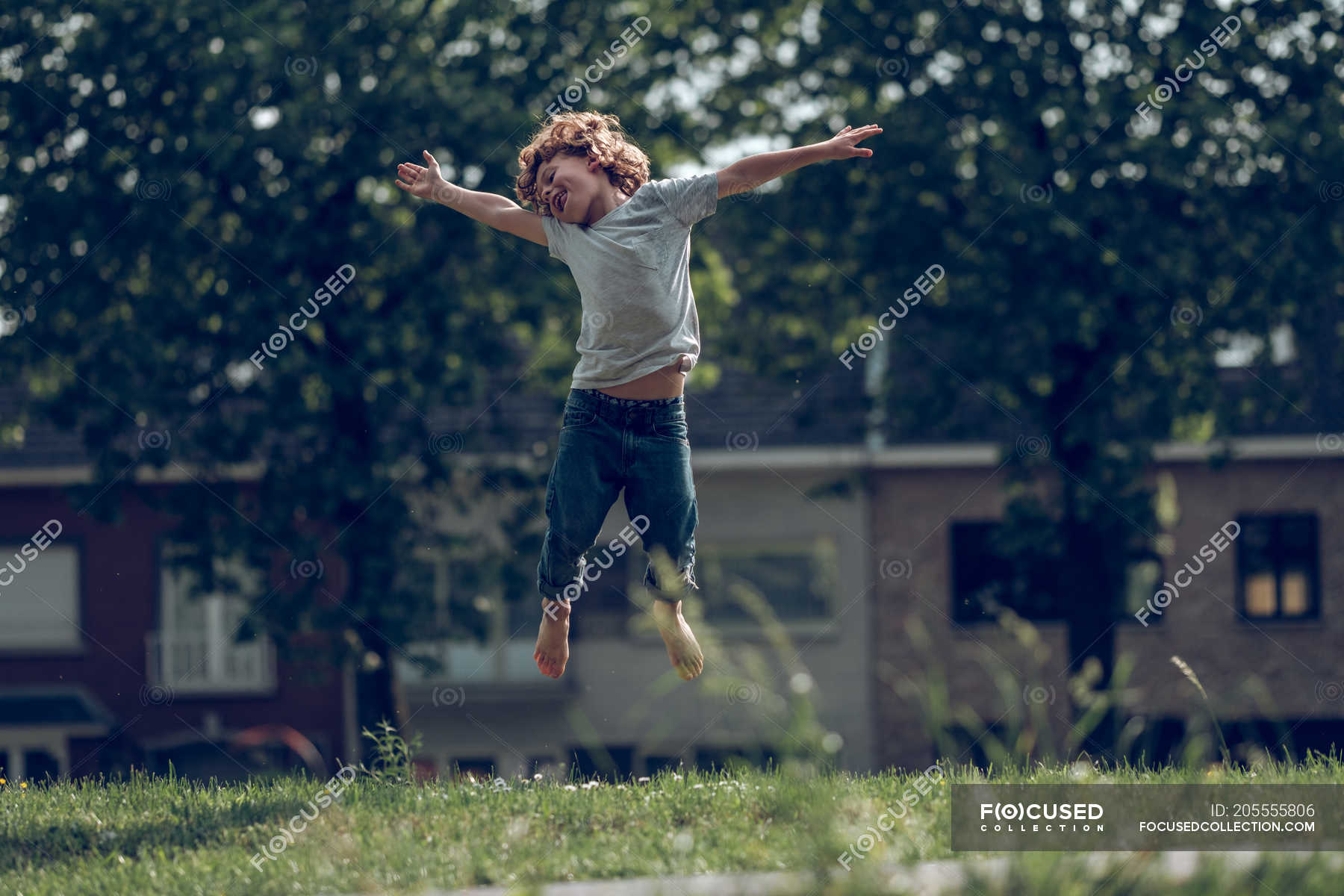 Excited boy jumping above grass — selective focus, outside - Stock ...