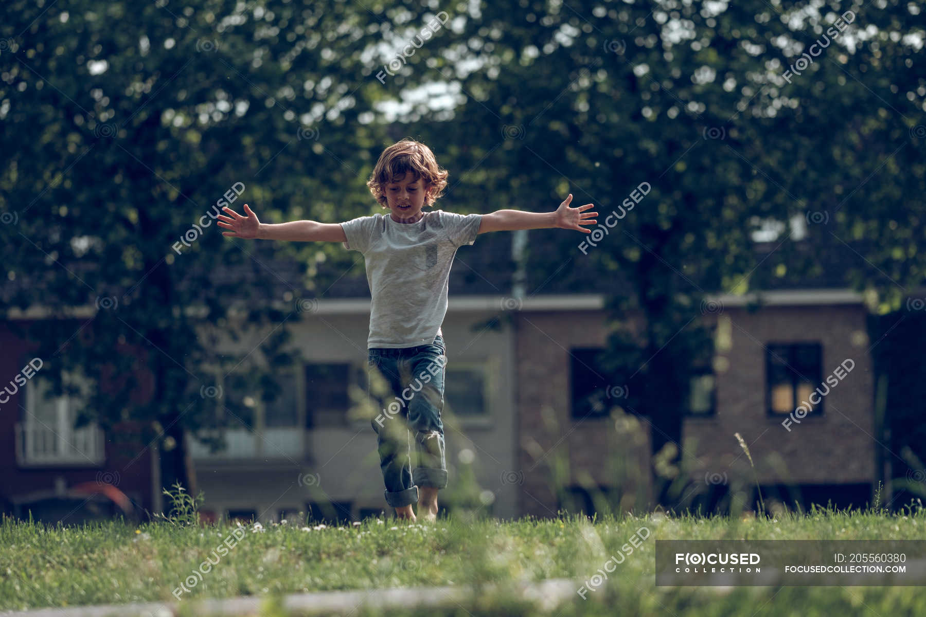 Excited boy jumping on grass — season, childhood - Stock Photo | #205560380