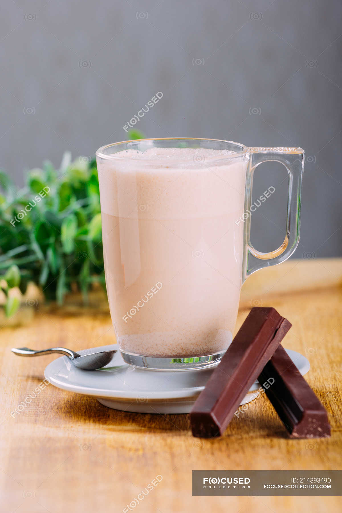 Glass Cup Of Milk On Saucer With Chocolate On Wooden Surface Sweet Vertical Stock Photo