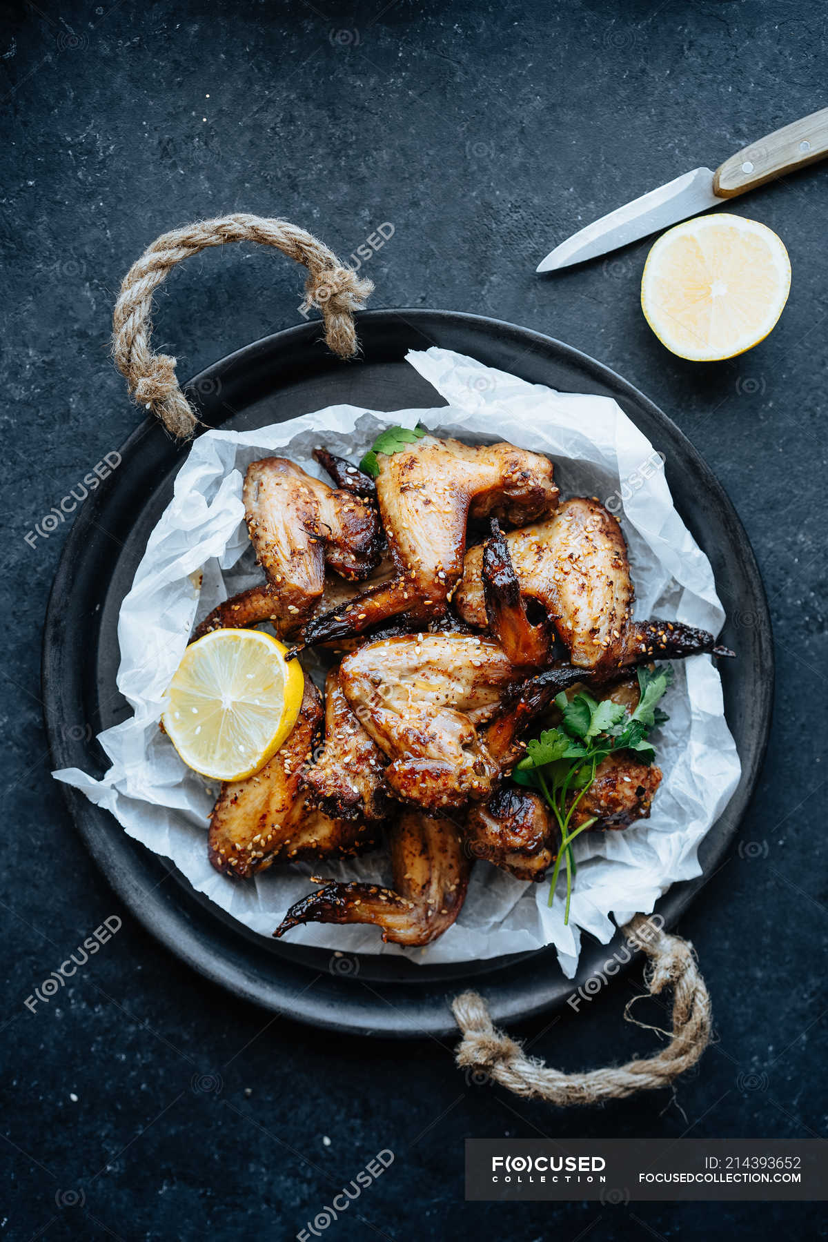 Baking dish of baked chicken wings in sesame and parsley with lemon