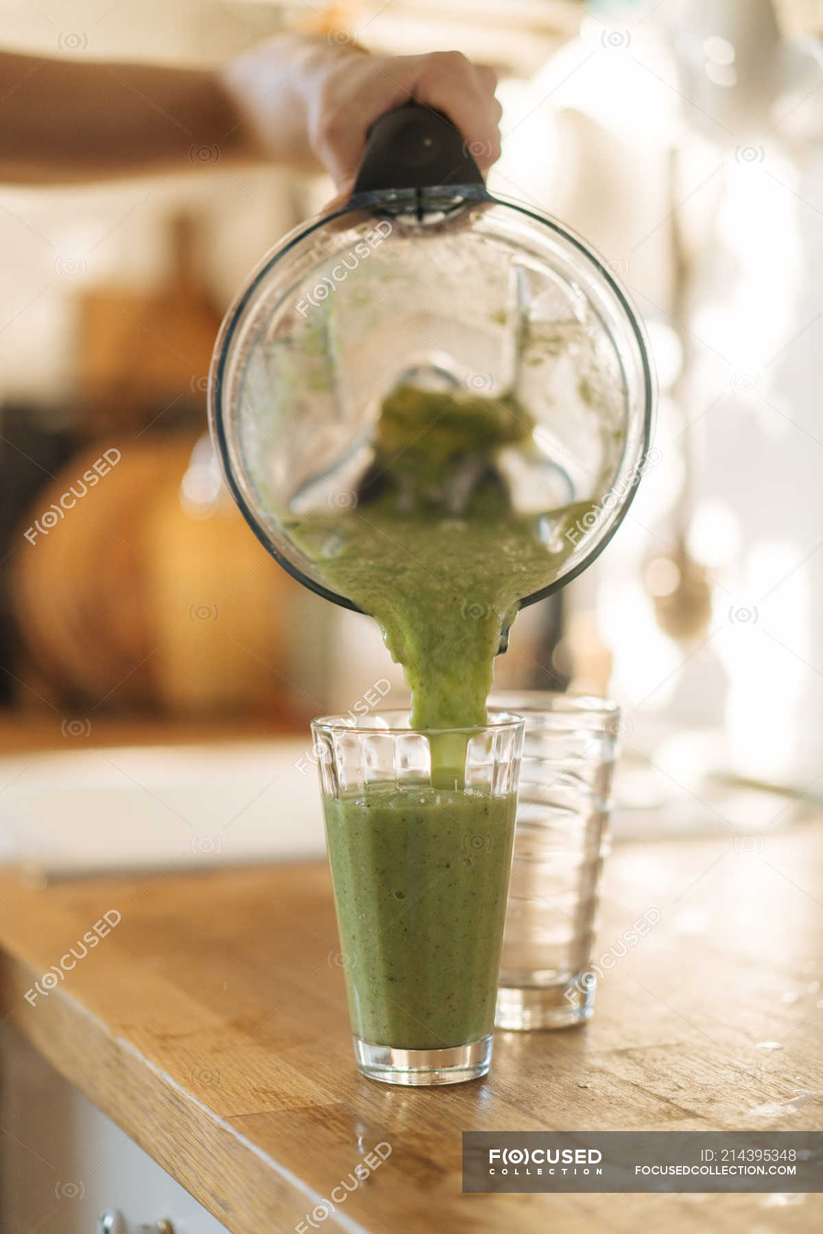 Human hand pouring smoothie in glass — products, fresh - Stock Photo |  #214395348