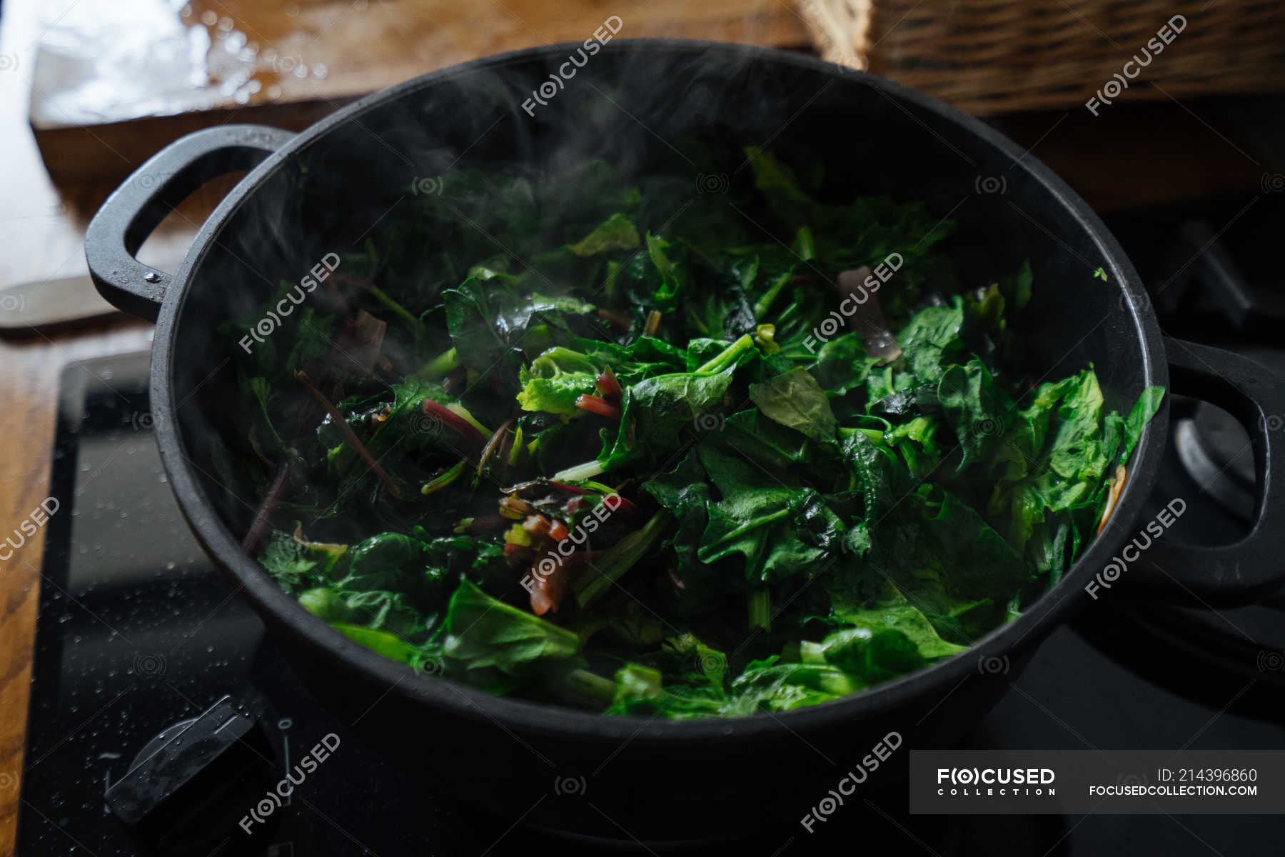 Cooking spinach leaves in pot on gas stove — cookery, green - Stock