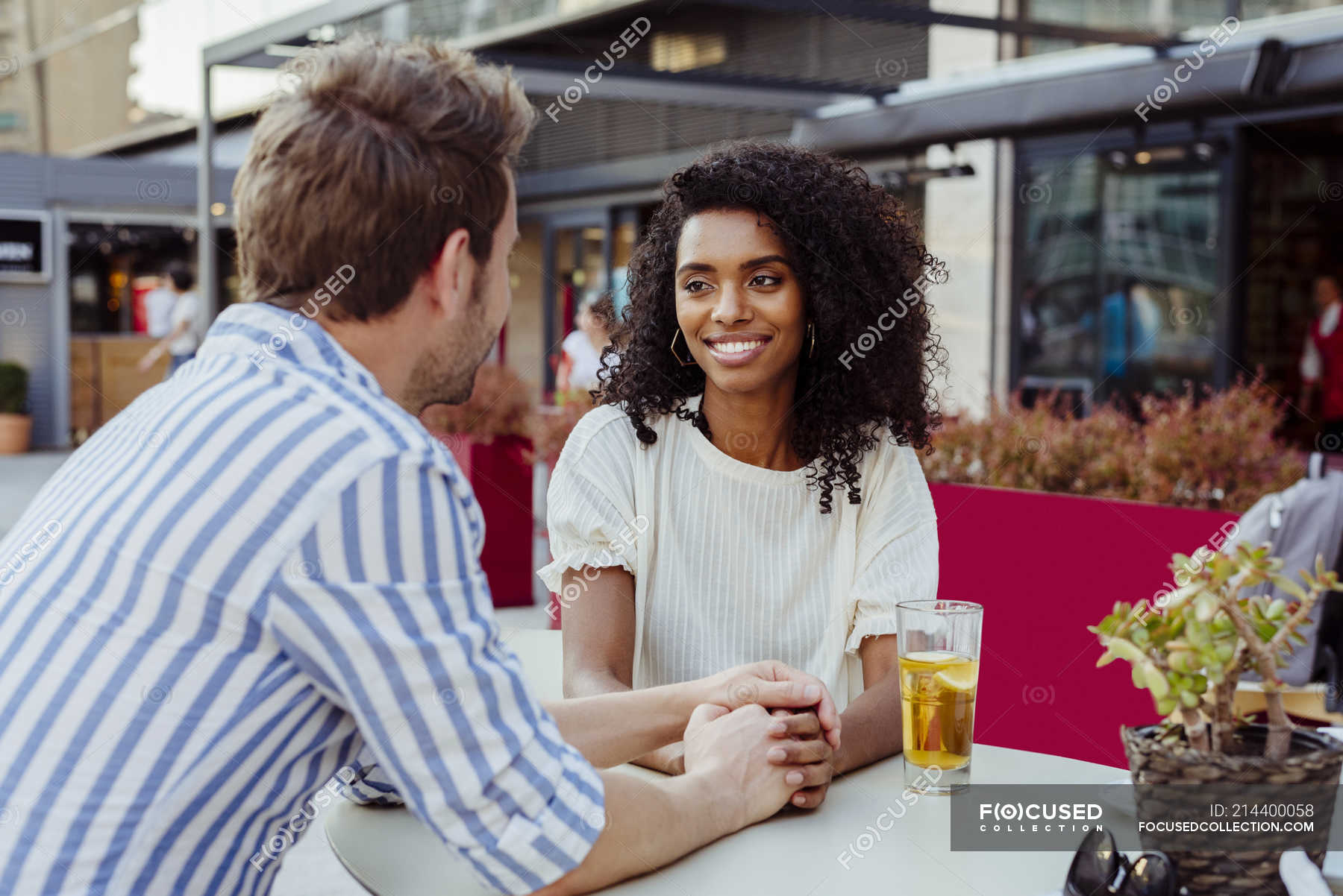 Romantic Multiracial Couple Holding Hands And Looking At Each Other While Sitting At Table In 2430