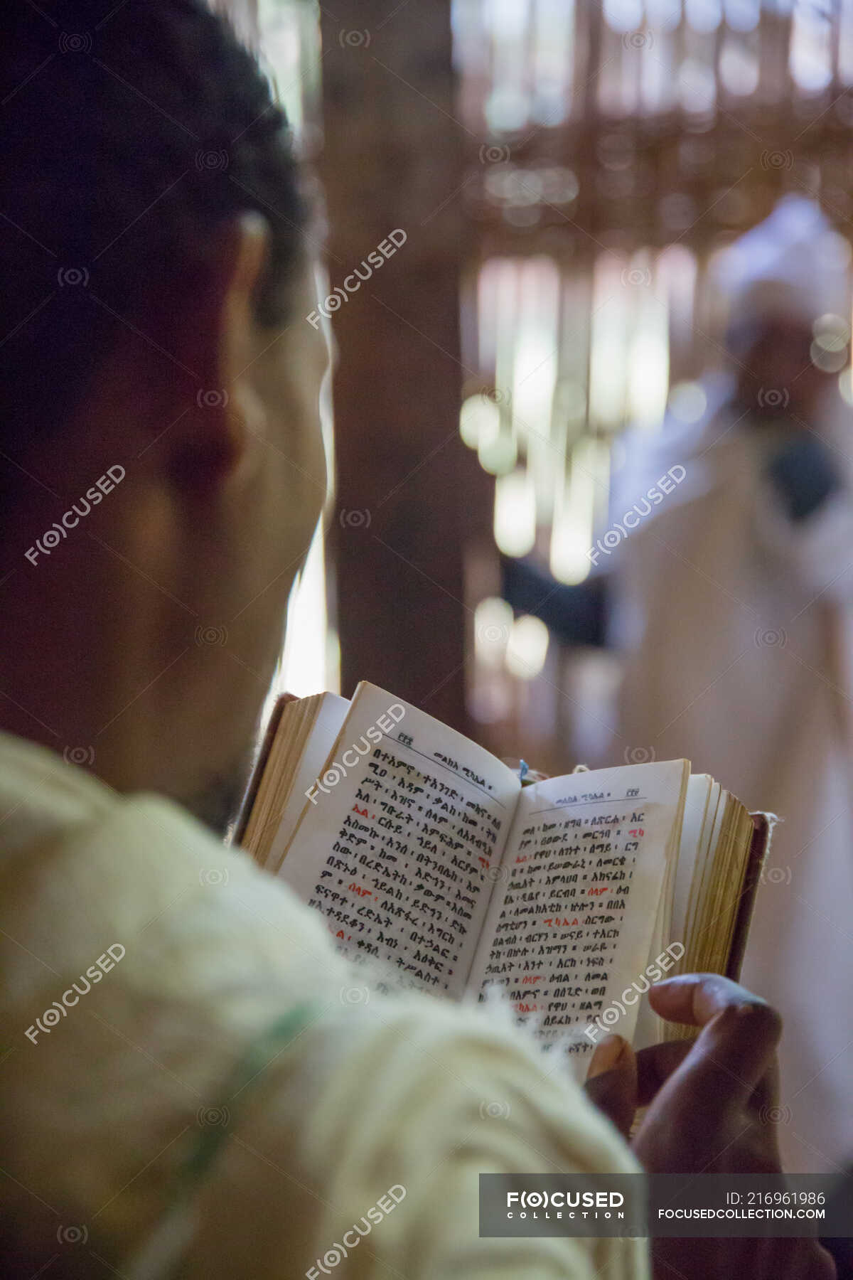 Crop back view of anonymous parishioner reading prayer book on blurred church  background — spirit, Gilded - Stock Photo | #216961986